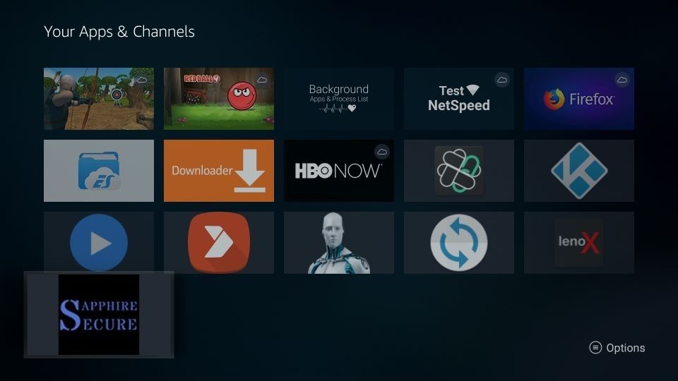A screenshot of the Amazon Firestick's "Your Apps & Channels" home screen grid. Prominent icons include Downloader, HBO NOW, Kodi, and an app for NetSpeed Test. A selected tile in the bottom-left corner shows the logo for "Sapphire Secure" with a blue and white design. [Sapphire IPTV Install on Firestick]